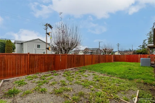 a view of backyard with wooden fence