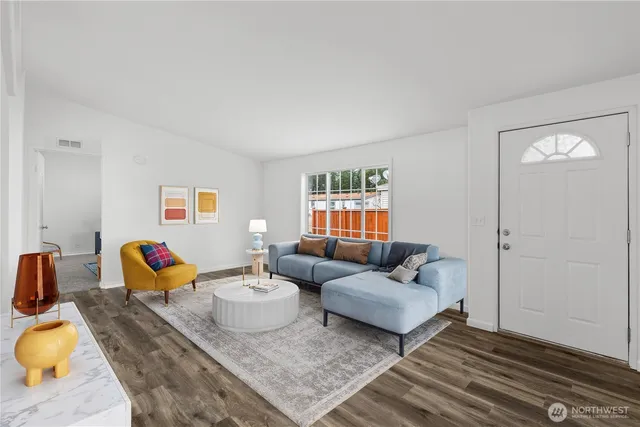 a living room with furniture and a wooden floor