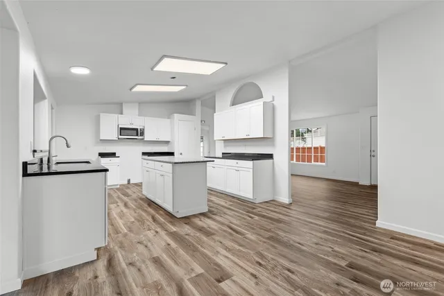 a kitchen with white cabinets and appliances