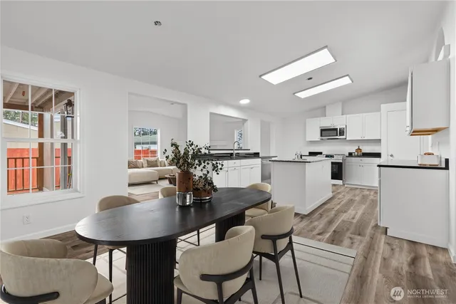 a kitchen with kitchen island a dining table and chairs