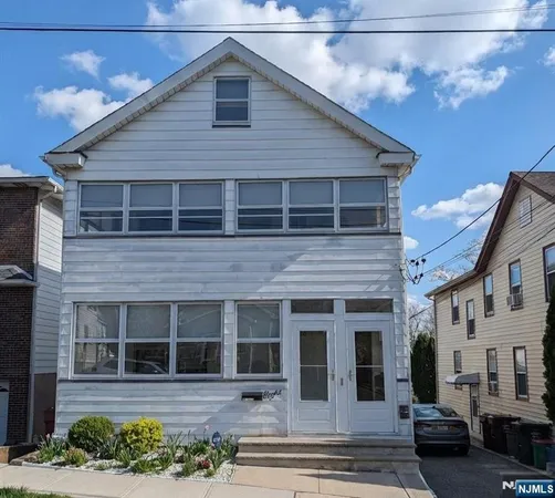 a view of a yard in front of a house with large windows