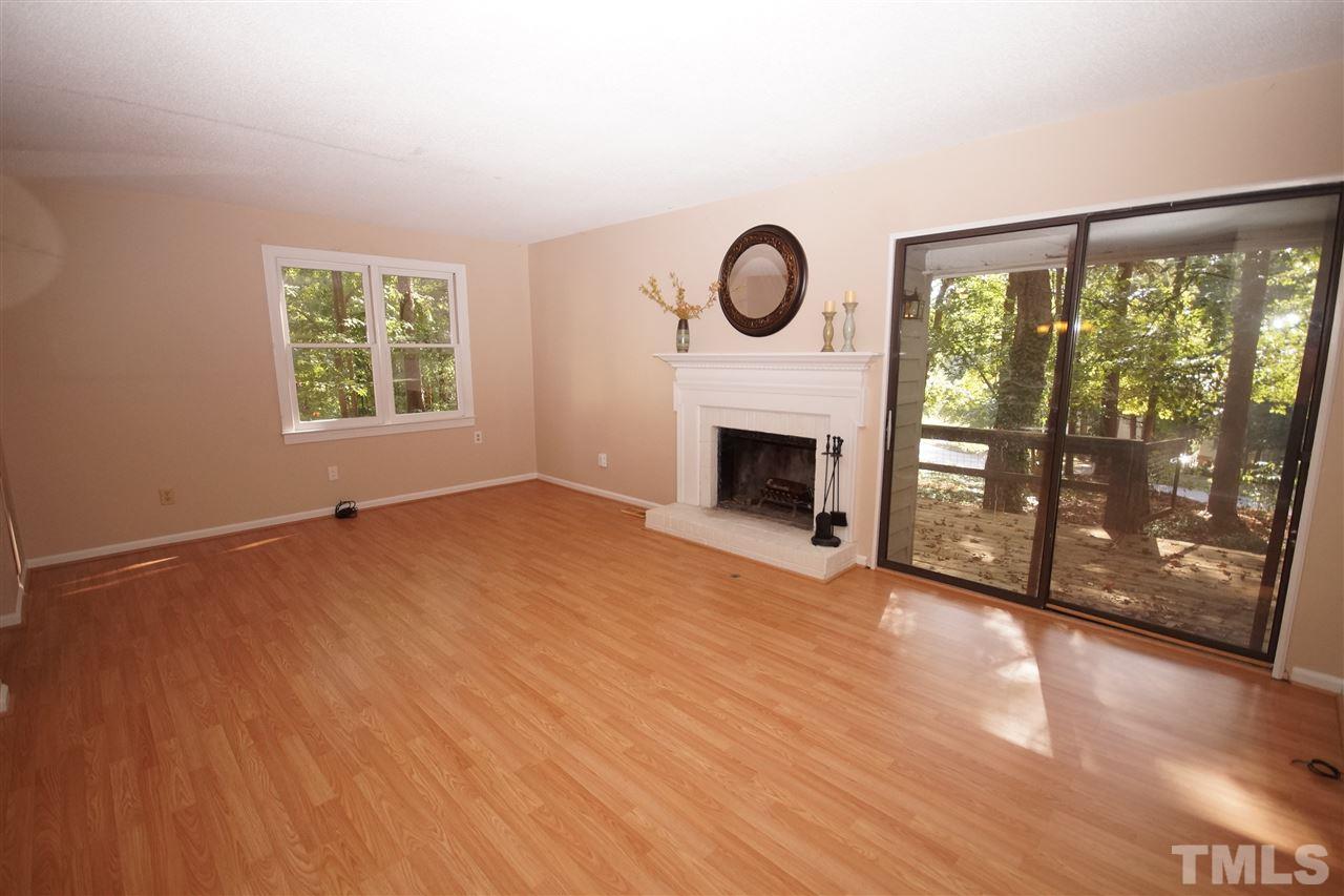 5719 Pool Side Drive Raleigh, NC 27612 - Photo 13 of 23 a view of empty room with wooden floor and fireplace