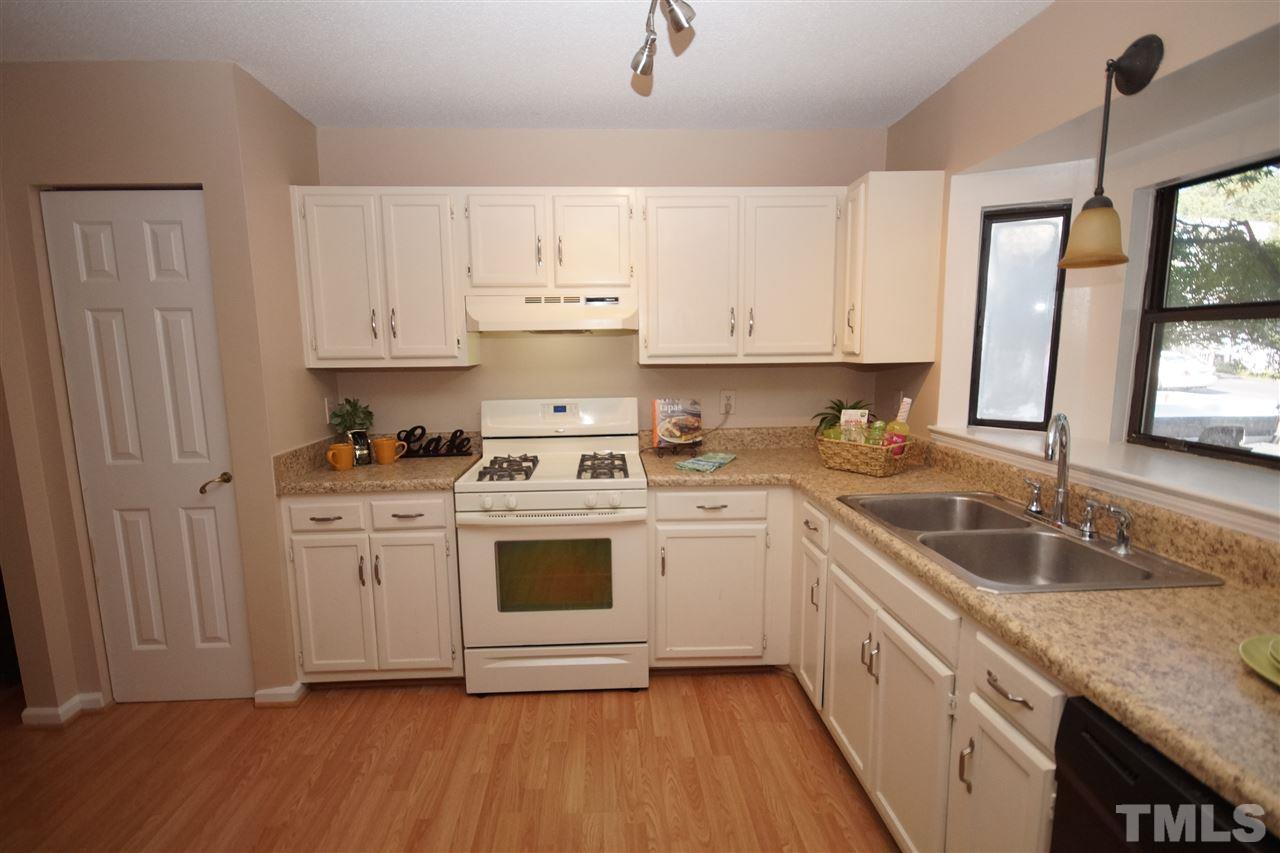 5719 Pool Side Drive Raleigh, NC 27612 - Photo 3 of 23 a kitchen with granite countertop white cabinets white appliances a sink and a window