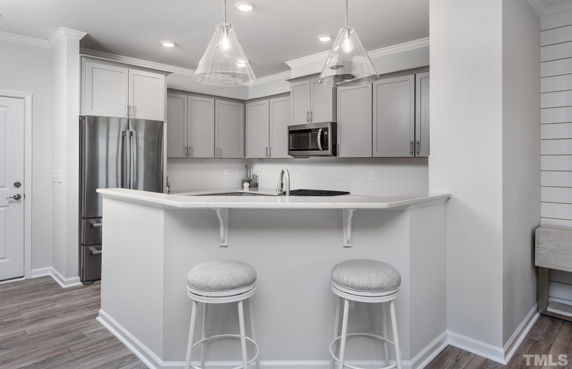 2400 Hedge Maple Drive, Unit ROYAL Raleigh, NC 27603 - Photo 11 of 16 a kitchen with stainless steel appliances a table and chairs