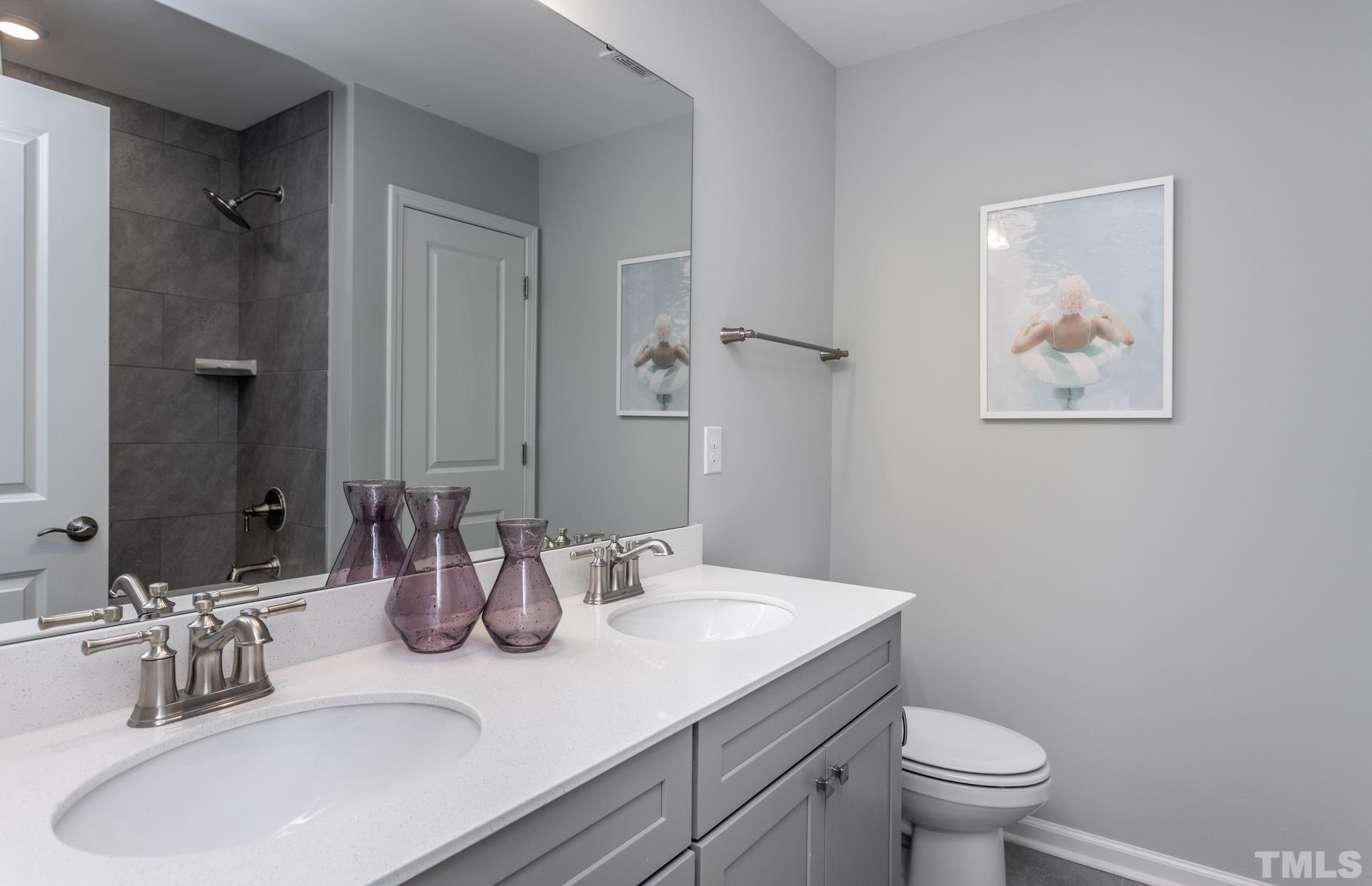 2400 Hedge Maple Drive, Unit ROYAL Raleigh, NC 27603 - Photo 10 of 16 a bathroom with a granite countertop sink a toilet and a mirror