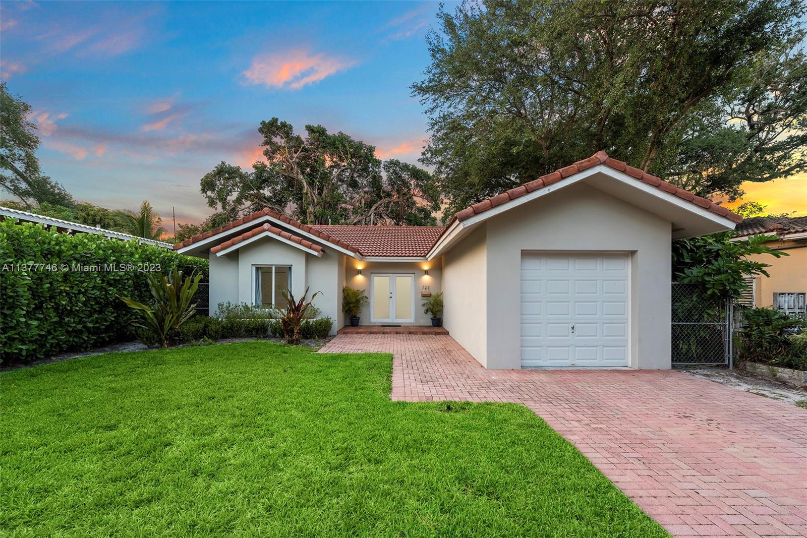 127 Northeast 90th Street El Portal, FL 33138 - Photo 1 of 32 a front view of a house with a yard and garage