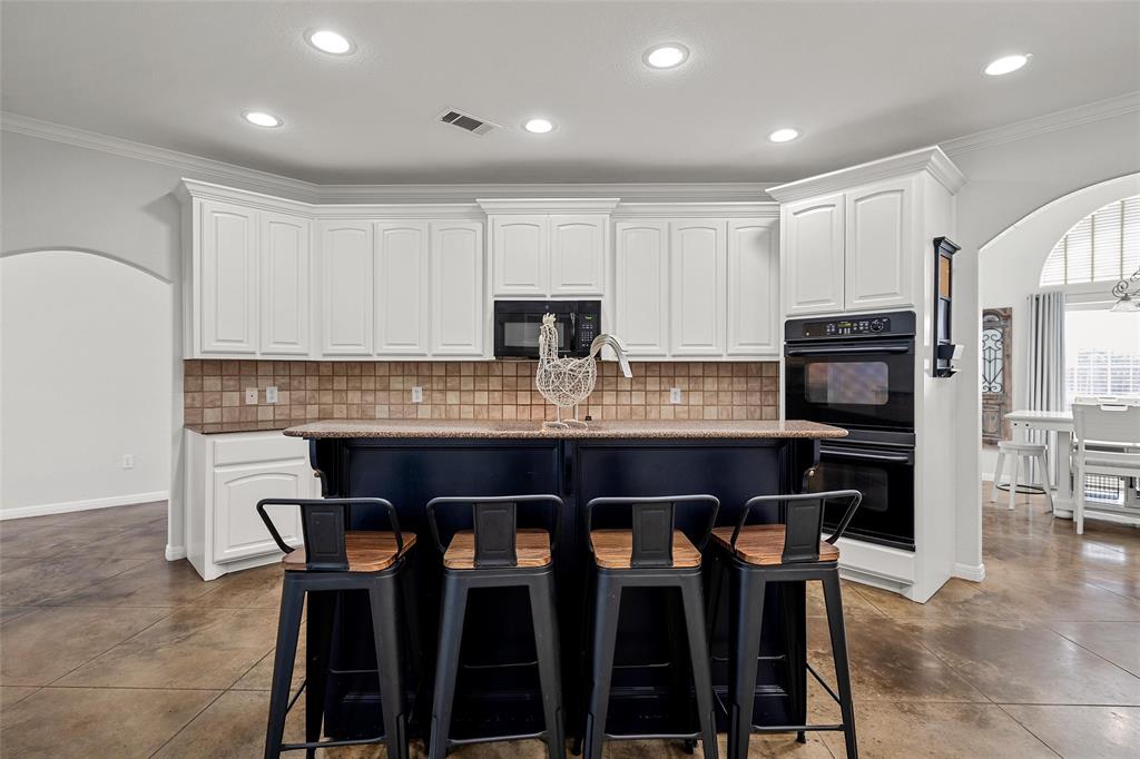 3696 Old Lorena Road Lorena, TX 76655 - Photo 9 of 27 Spacious kitchen featuring an expansive central island, white cabinetry, integrated black double ovens, a built-in microwave, and tile backsplash