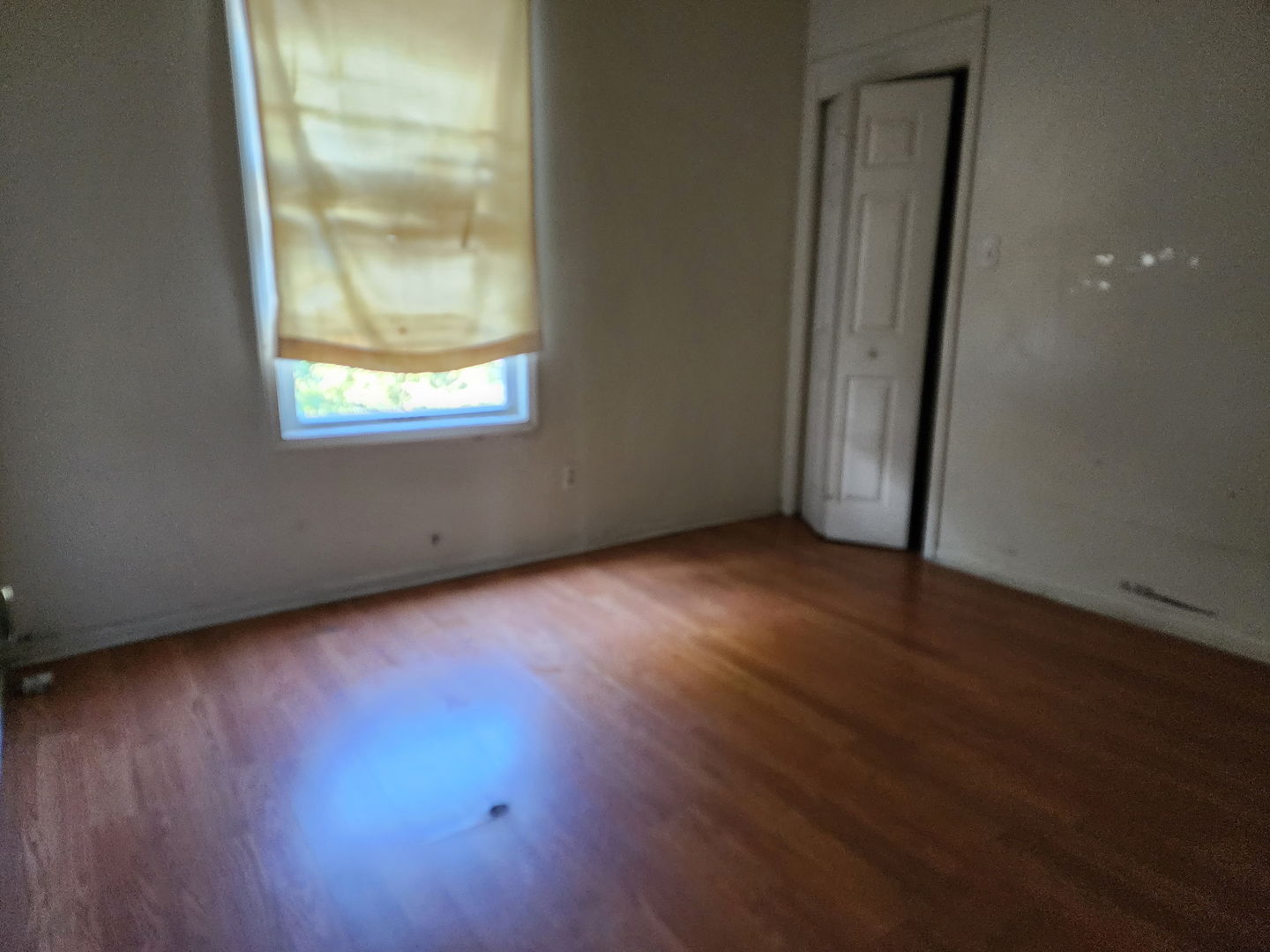 5718 South Green Street Chicago, IL 60621 - Photo 4 of 17 an empty room with wooden floor and windows