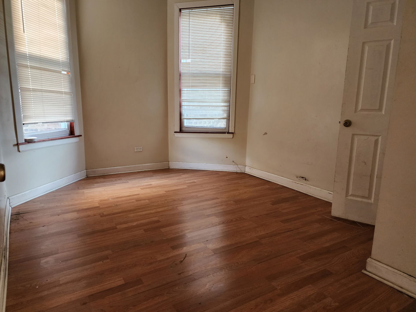 5718 South Green Street Chicago, IL 60621 - Photo 8 of 17 an empty room with wooden floor and windows