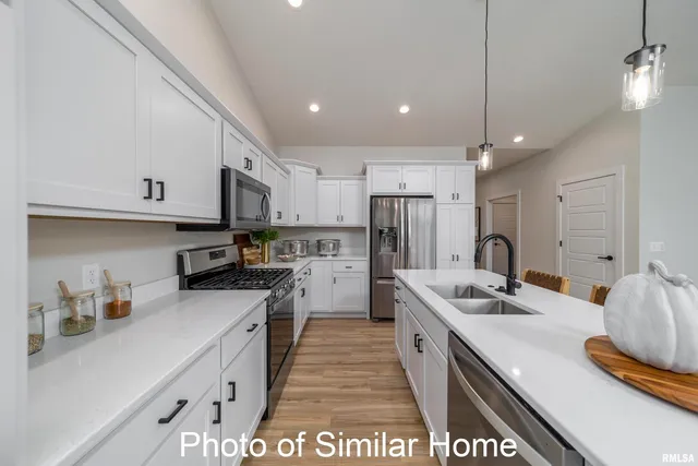 a kitchen with stainless steel appliances a sink a stove a refrigerator and cabinets