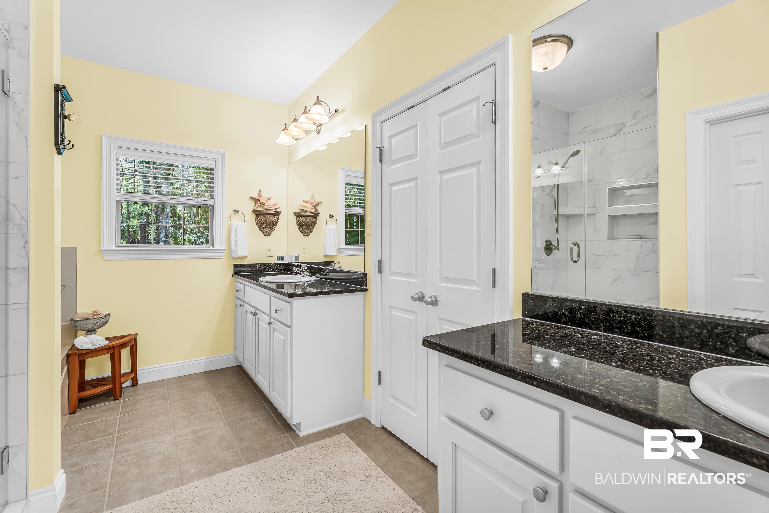 7014 Blakeley Road Daphne, AL 36527 - Photo 38 of 45 Bathroom featuring a double vanity with dark countertops and white cabinetry