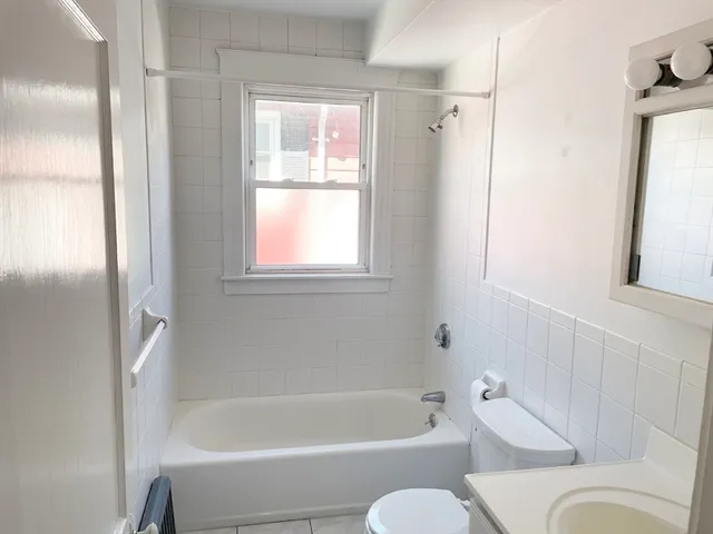 a bathroom with a tub shower and a sink