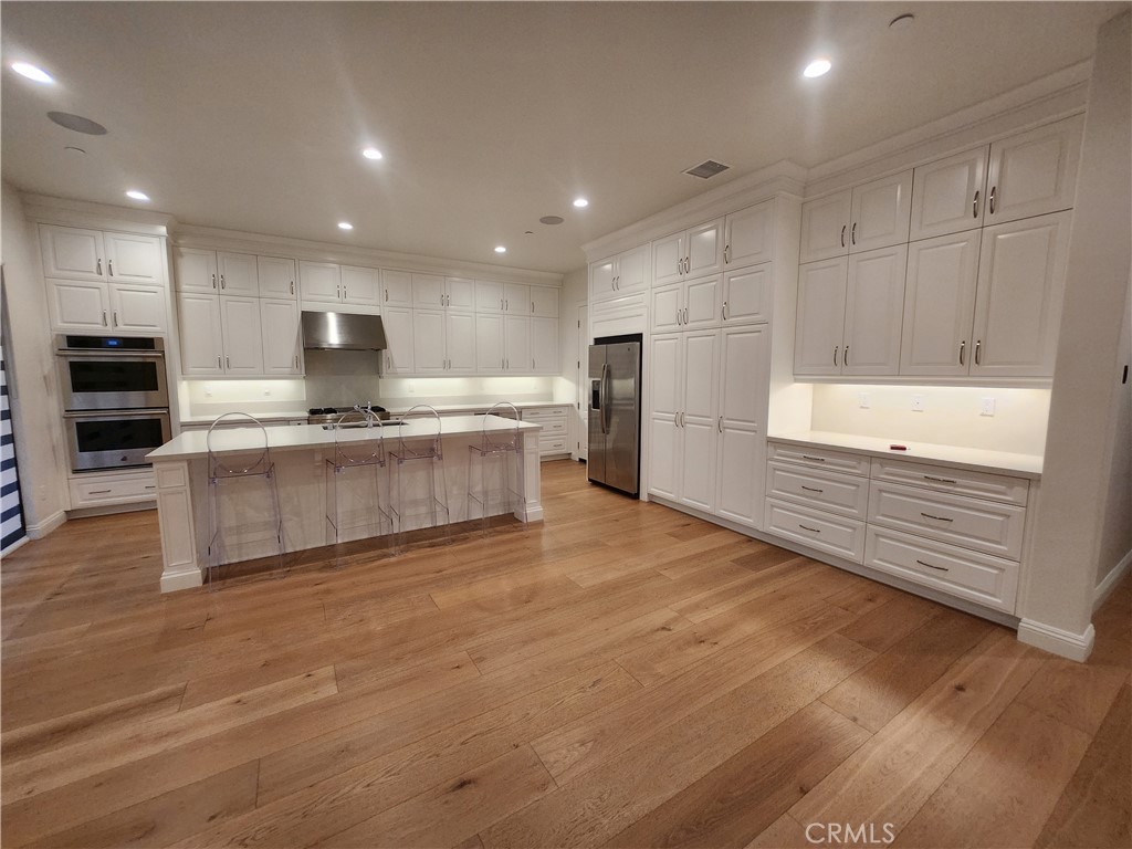 20717 Pine Cone Circle Porter Ranch, CA 91326 - Photo 18 of 31 a large kitchen with kitchen island a sink stainless steel appliances and cabinets