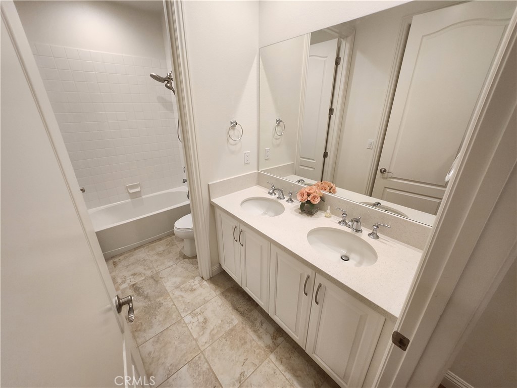 20717 Pine Cone Circle Porter Ranch, CA 91326 - Photo 27 of 31 a bathroom with a double vanity sink a toilet and a large mirror
