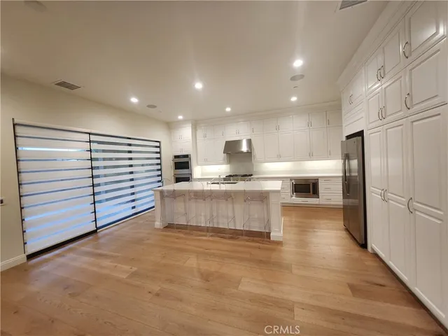a kitchen with stainless steel appliances granite countertop a refrigerator and a stove