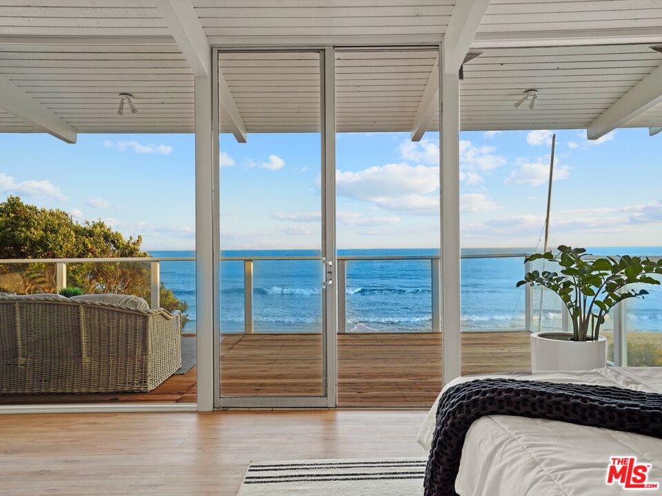 31284 Broad Beach Road Malibu, CA 90265 - Photo 17 of 31 a bedroom with a balcony a bed and a potted plant
