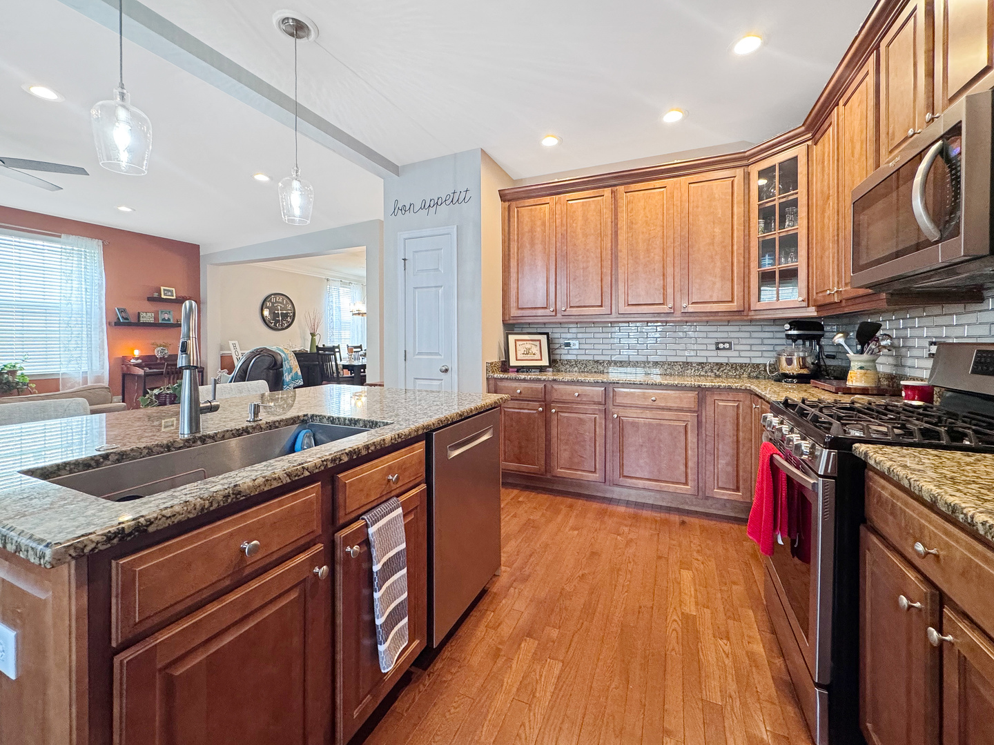1210 Falcon Ridge Drive Elgin, IL 60124 - Photo 15 of 35 a large kitchen with stainless steel appliances granite countertop a stove a sink dishwasher a microwave oven and a dining table with wooden floor