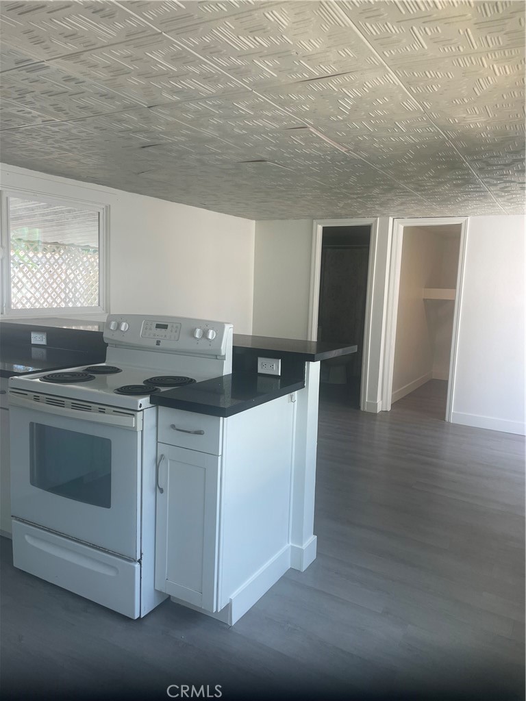 32802 Valle Road, Unit 135 San Juan Capistrano, CA 92675 - Photo 5 of 26 a kitchen with granite countertop a stove and a sink