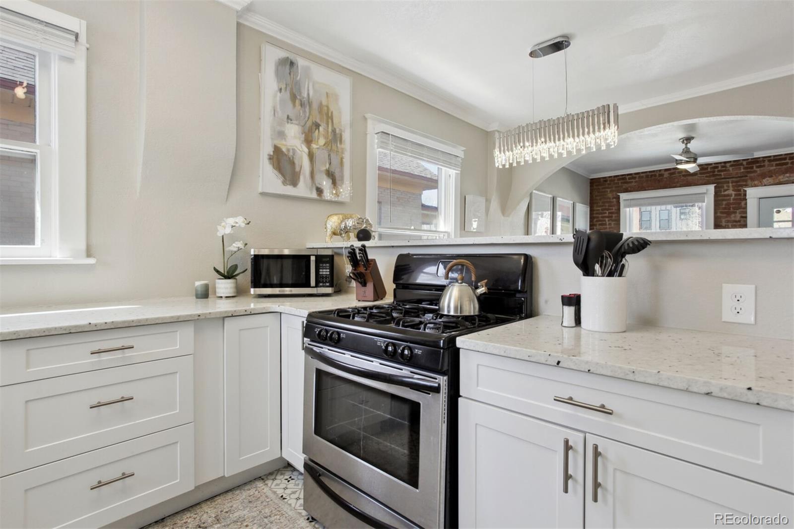 4138 Shoshone Street Denver, CO 80211 - Photo 9 of 27 a kitchen with granite countertop cabinets stainless steel appliances and a window