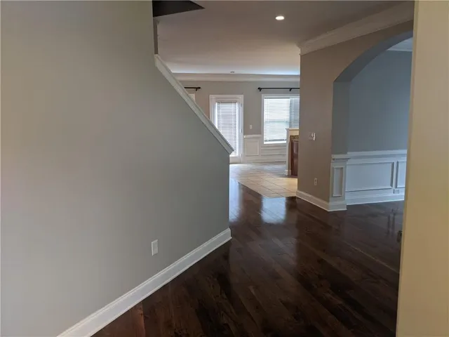 a view of a hallway with wooden floor and staircase