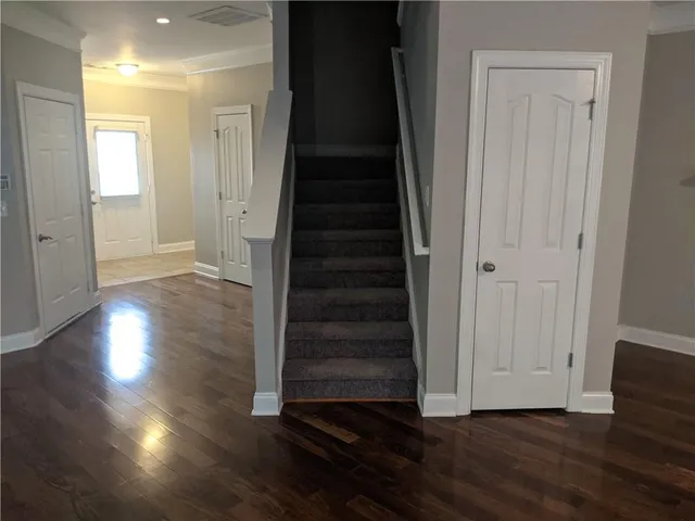 a view of a hallway with wooden floor and entryway