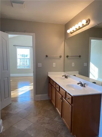 a spacious bathroom with a granite countertop sink a mirror and a shower