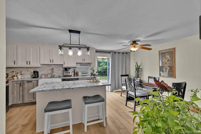 a kitchen with stainless steel appliances granite countertop a stove top oven a dining table and chairs with wooden floor