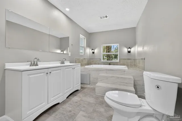 a bathroom with a sink toilet and mirror