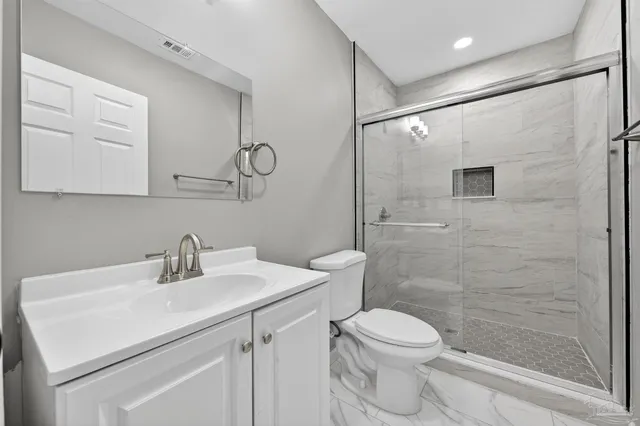 a bathroom with a sink a toilet and shower