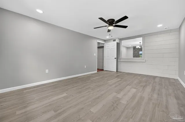a view of a livingroom with a ceiling fan & wooden floor
