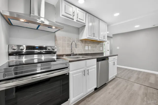 a kitchen with stainless steel appliances granite countertop a stove and cabinets