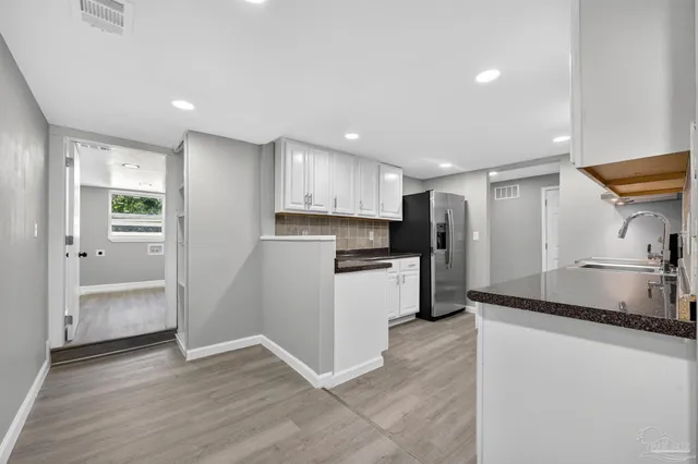 a kitchen with stainless steel appliances granite countertop a refrigerator and a sink