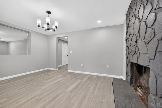 an empty room with a fireplace and wooden floor