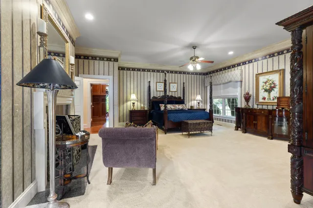 a spacious bedroom with a bed couch and window