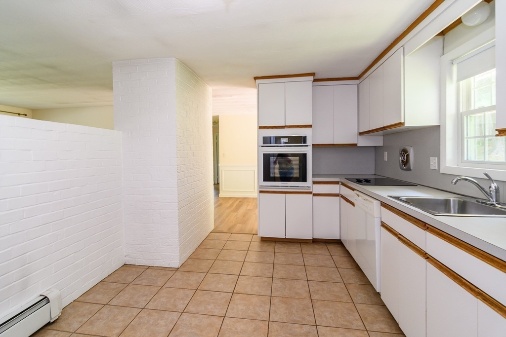 33 Eisenhower Road Framingham, MA 01701 - Photo 9 of 20 a kitchen with a sink a stove top oven and cabinets