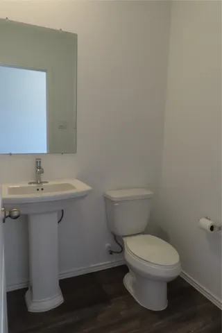 a bathroom with a toilet a sink and mirror