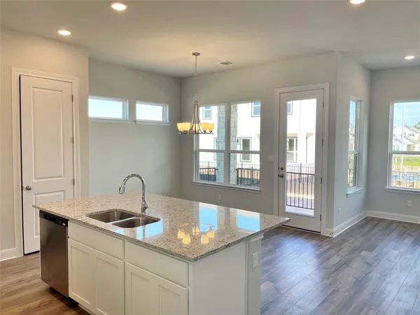 a kitchen with a sink cabinets and wooden floor