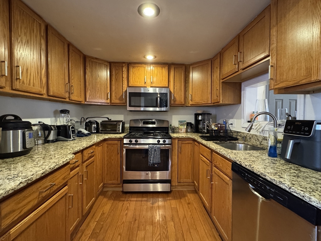 286 Bowen Street Boston, MA 02127 - Photo 2 of 12 a kitchen with stainless steel appliances granite countertop wooden cabinets a stove top oven a sink and dishwasher