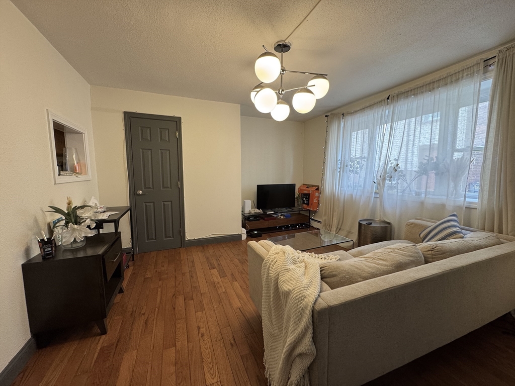 286 Bowen Street Boston, MA 02127 - Photo 5 of 12 a bedroom with a bed and wooden floor