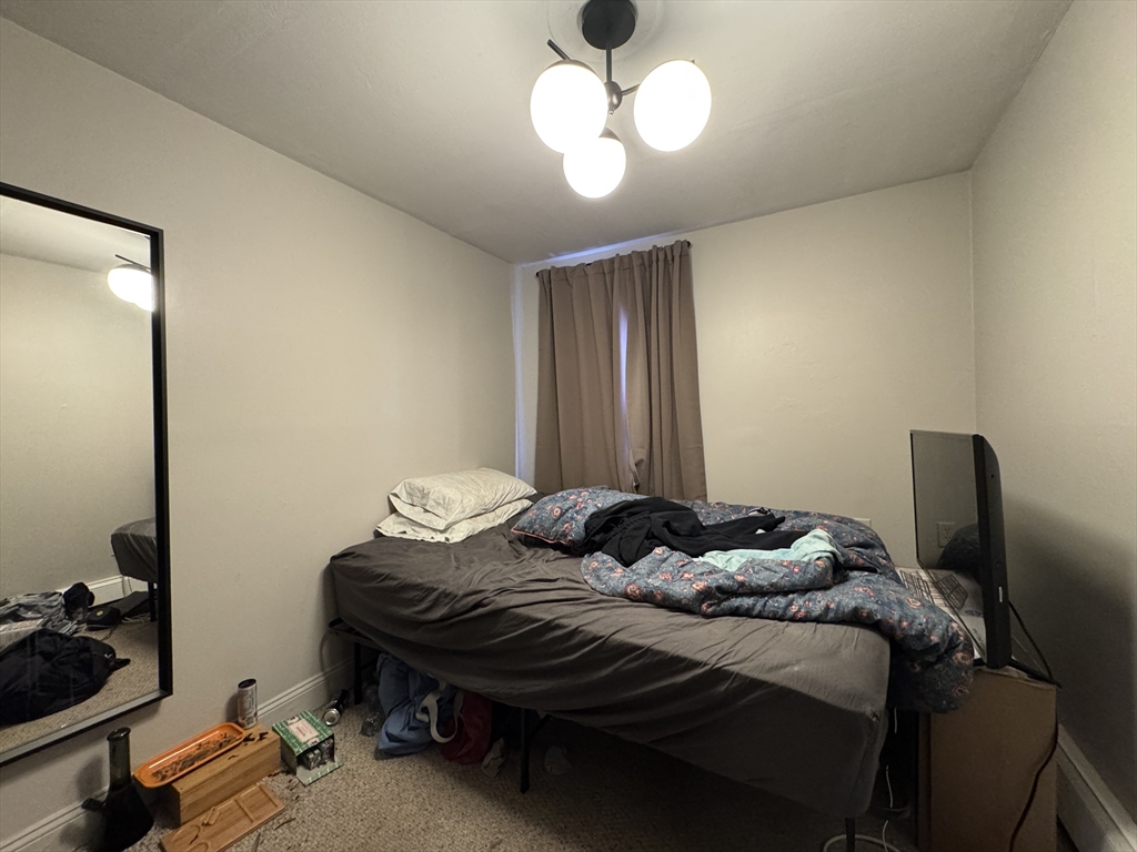 286 Bowen Street Boston, MA 02127 - Photo 7 of 12 a bedroom with a bed and a chandelier