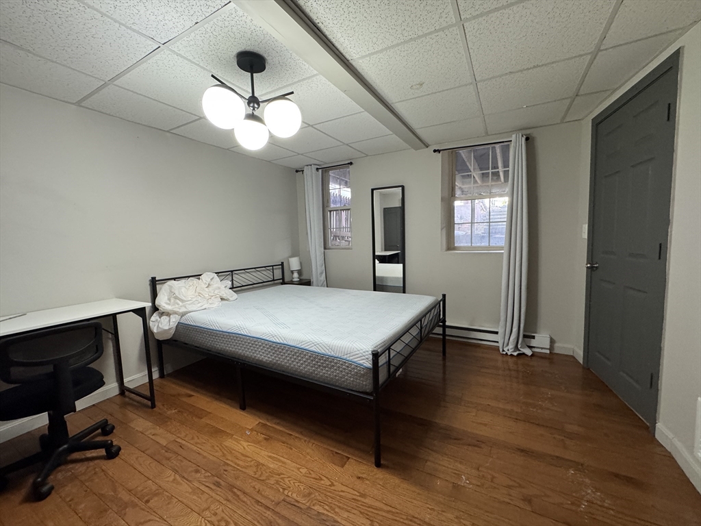 286 Bowen Street Boston, MA 02127 - Photo 8 of 12 a bedroom with a bed and a chandelier
