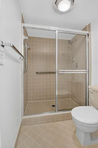 a bathroom with a shower a toilet and a sink