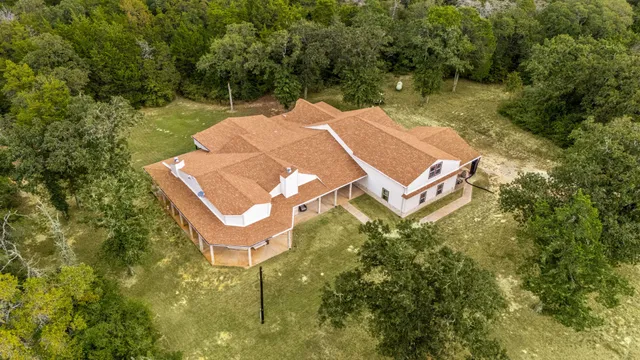 an aerial view of a house with swimming pool and outdoor space