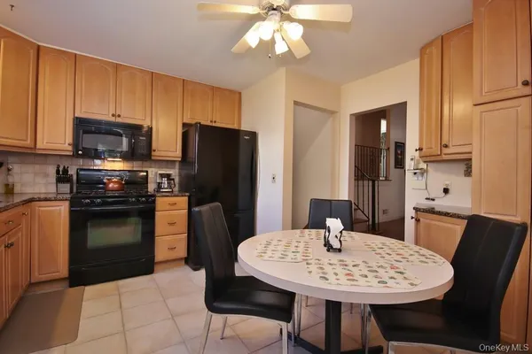 a kitchen with stainless steel appliances a dining table a refrigerator and microwave
