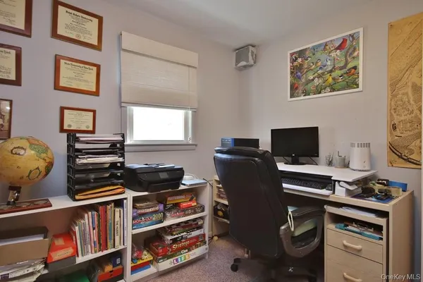 a view of a workspace with furniture and a window