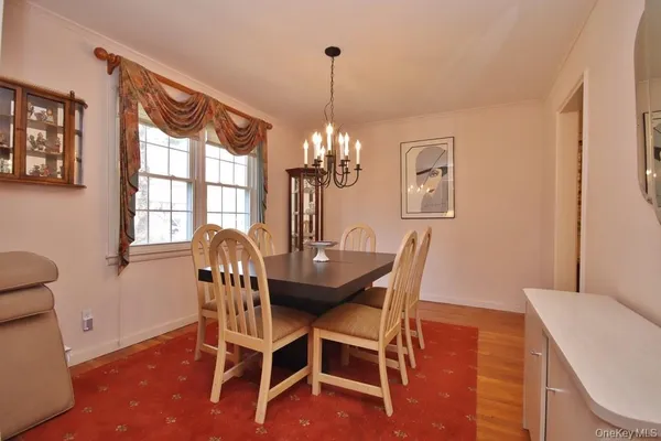 a dining room with furniture a chandelier and wooden floor