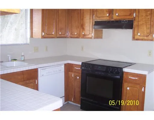 a kitchen with granite countertop a sink cabinets and a wooden floor