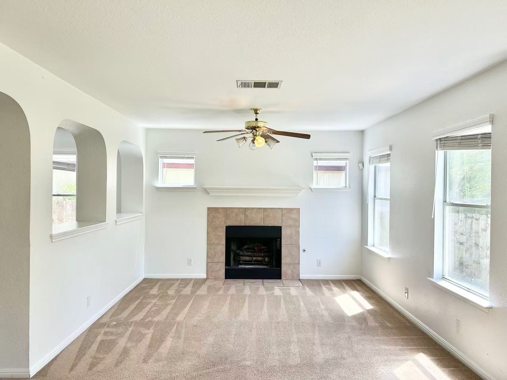 5608 Netleaf Road Austin, TX 78724 - Photo 8 of 26 A cozy living area features a charming tile-surrounded fireplace and soft carpeted flooring.