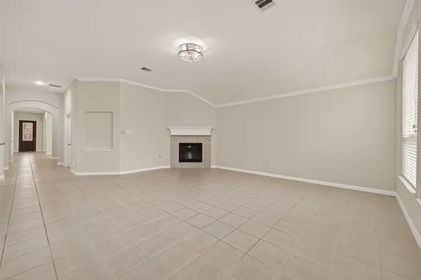 an empty room with windows and fireplace