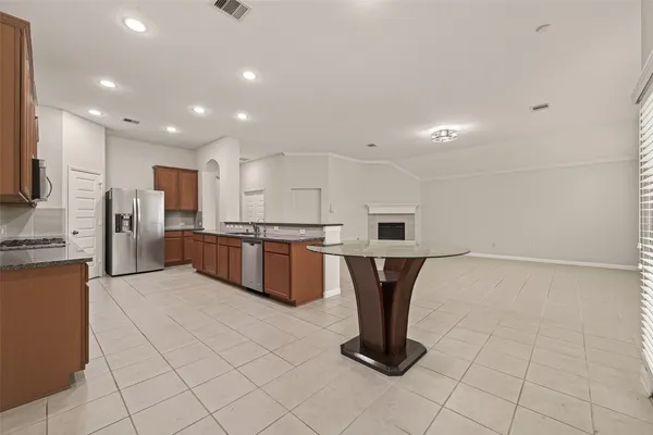 a large kitchen with stainless steel appliances granite countertop a large counter top a stove and a sink
